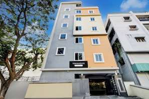 A multi-story building with a sign indicating it is a serviced company property. - Super Townhouse Lanco Hills Gachibowli (Hyderabad)