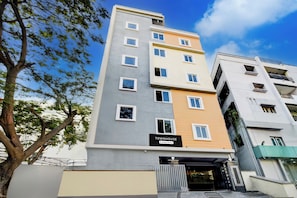 A multi-story residential building with a sign indicating it is a company-serviced townhouse. - Super Townhouse Lanco Hills Gachibowli (Hyderabad)