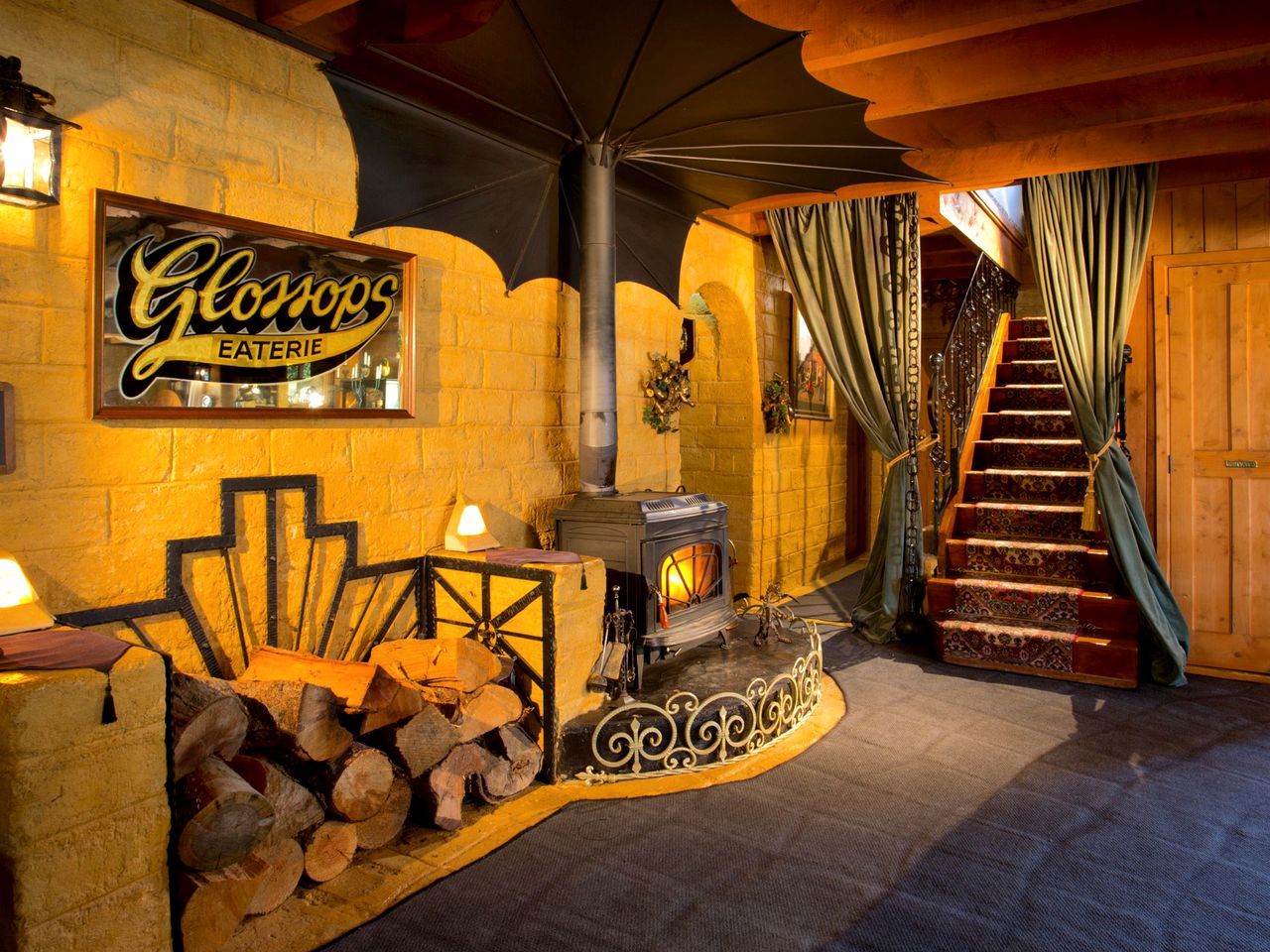 Ein gemütliches Interieur mit Kaminofen, einer Treppe und einem Schild für 'Glonops EATERIE'.