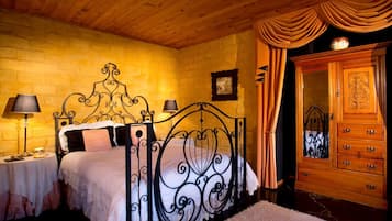 Une chambre à coucher avec un plafond en bois, un lit avec un cadre en métal, une table de chevet, une commode et un miroir.