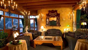 Una habitación acogedora con chimenea, muebles de madera y un tablero de ajedrez.