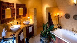 A bathroom with a large bathtub, two sinks, and a mirror. - Luxury Castle for Large Groups in Nelson, New Zealand (Upper Moutere)