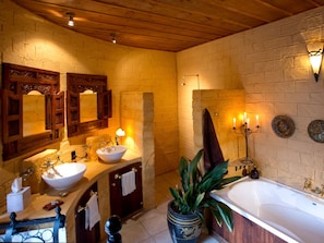 A bathroom with a large bathtub, two sinks, and a mirror. - Luxury Castle for Large Groups in Nelson, New Zealand (Upper Moutere)