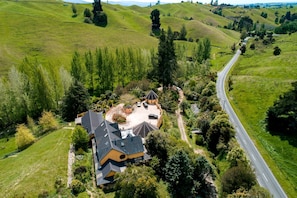 A residential property with a large house, a driveway, and a road.