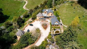 A large house with a spacious driveway, surrounded by lush greenery and trees.