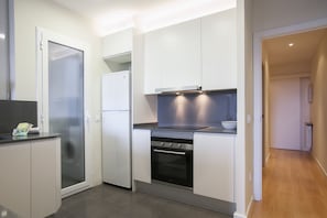 A modern kitchen with white cabinetry, a built-in oven, and a glass door refrigerator. - Apartment with Balcony near Sagrada Familia – Aragón 528Perfect for families, getaways with friends, or romantic weekends, this cozy three-bedroom, two-bathroom apartment offers everything you need to enjoy Barcelona like a true local. Just steps from (Barcelona)