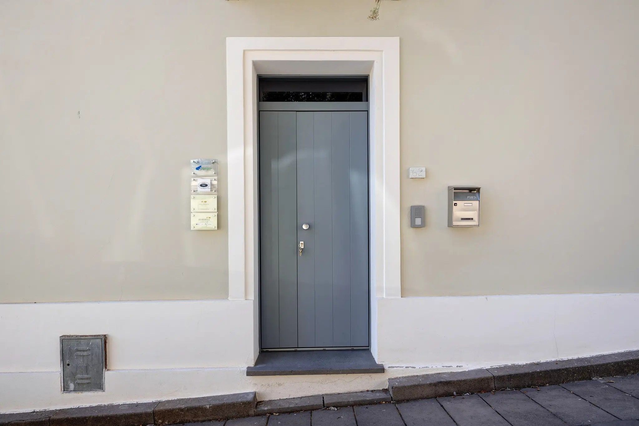 Une porte avec une fente pour le courrier et une boîte aux lettres fixée au mur.