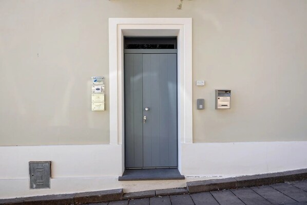 A door with a mail slot and a mailbox on the wall.