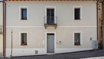 Un edificio a due piani con un balcone, una porta e finestre.