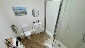Un bagno con servizi igienici, lavandino e doccia.