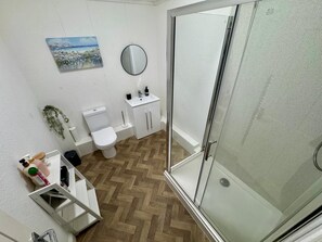Un baño con inodoro, lavabo y ducha.