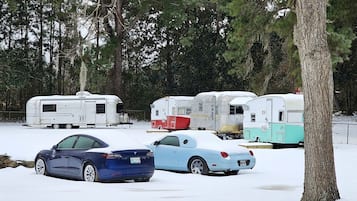Ein Parkplatz mit autos und Anhängern, die mit Schnee bedeckt sind.
