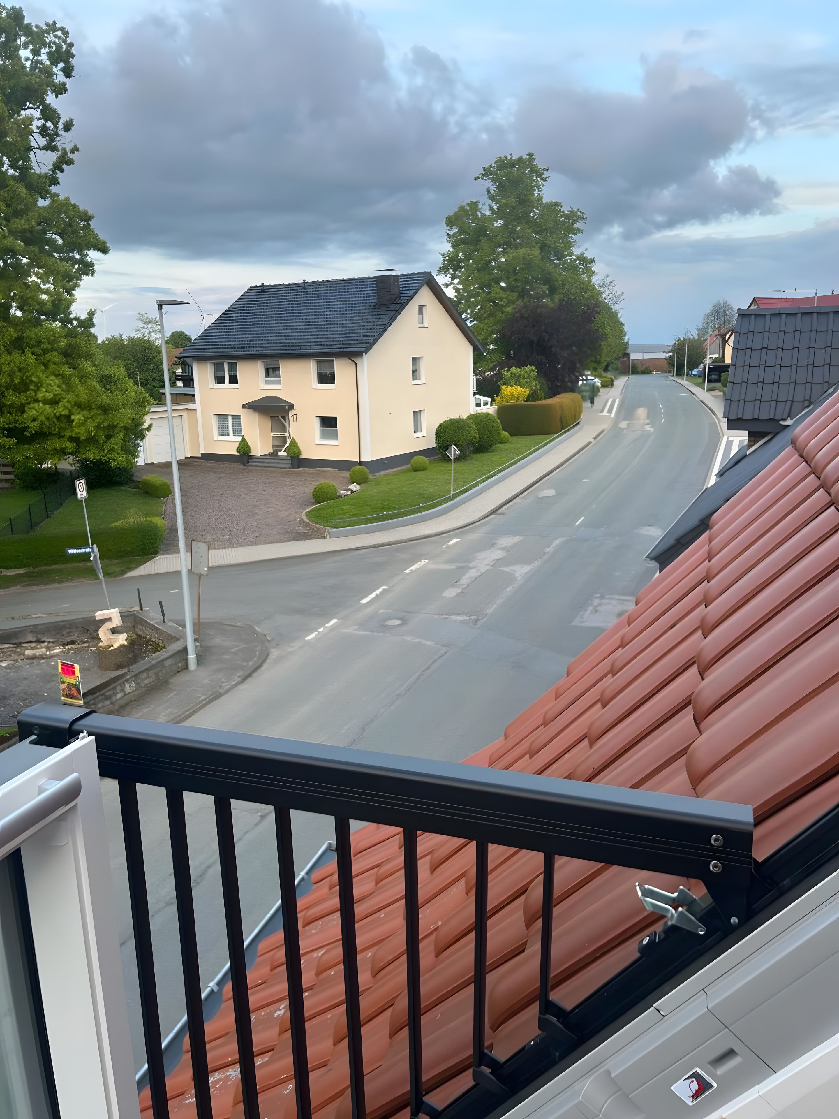En bostadsgata med hus, en klar himmel och ett övergångsställe för fotgängare.