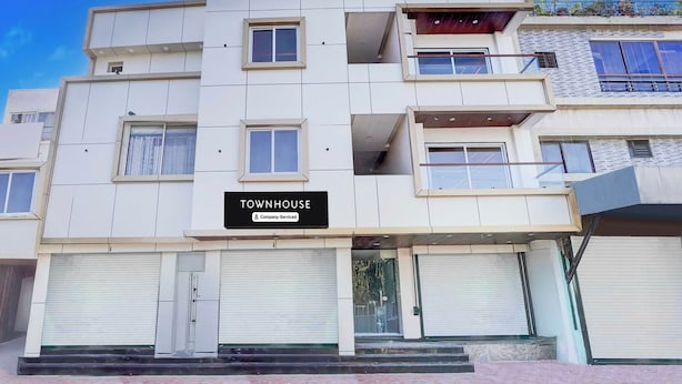 A multi-story building with a sign indicating it is a company-serviced townhouse. - Townhouse Khajrana Ganpati Mandir (Indore)