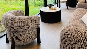Un intérieur moderne avec de grandes fenêtres, une table ronde et deux canapés.