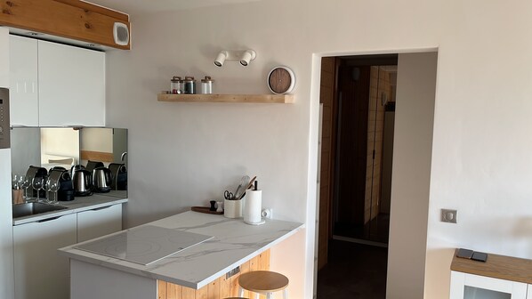 Cozinha moderna com ilha central, forno embutido e bancada de madeira.