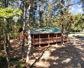 Una cabana amb un porxo, envoltada d'arbres.
