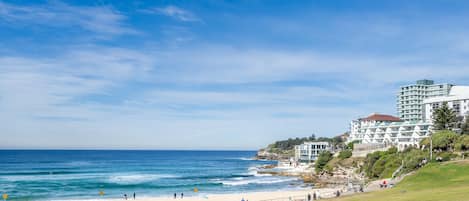 A coastal view with a beach, ocean, and buildings.