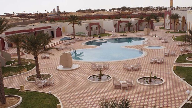 A pool area with multiple circular pools, lounge chairs, and palm trees. - Offra Douz  (Ghlissia)