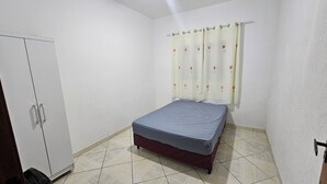 A bedroom with a bed, a wardrobe, and a curtain. - House for 6. Private pool | Hot tub (Pindamonhangaba)