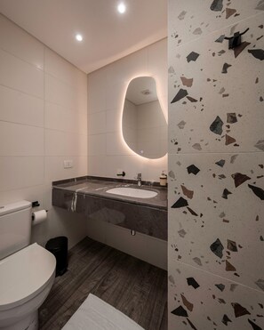 A modern bathroom with a white toilet, a sink with a marble countertop, and a mirror with an oval frame. - Amazing Deal at 22 by Spacey #41 (cairo)