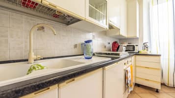 A kitchen with a sink, faucet, and a microwave.