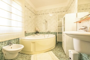 A bathroom with a bathtub, a sink, and a bidet. - Villa Querciolo (Toscana)