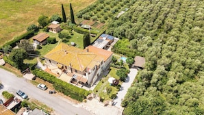 Ein geräumiges Haus mit Ziegeldach, umgeben von einem gepflegten Garten und einem Weinberg.