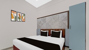 A modern bedroom with a large bed, a headboard with a geometric pattern, and three framed artworks on the wall. - Townhouse Oak Thondayad Calicut Dream (Calicut)