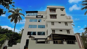 A multi-story building with a sign indicating it is a company-serviced townhouse. - Townhouse Oak Thondayad Calicut Dream (Calicut)
