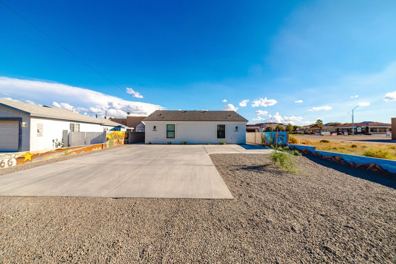A residential area with a single-story house, a driveway, and a parking lot.