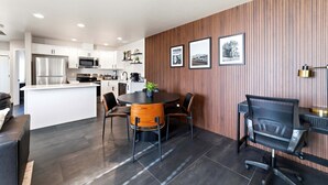 A modern kitchen with white cabinets, stainless steel appliances, and a central island. - Work-Ready Stay with Desk + ALLO Fiber WiFi (Kingman)
