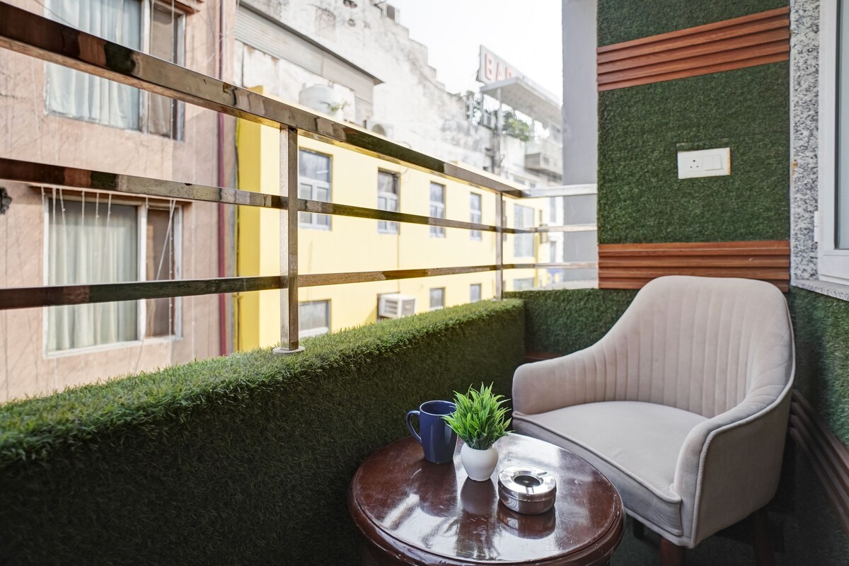 A balcony with a chair, a small table, and a potted plant.
