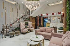 Un moderno vestíbulo de hotel con escalera, asientos cómodos y una recepción.