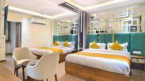 Een hotelkamer met twee bedden, een zithoek en een decoratieve wand.
