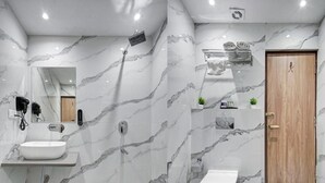 Een moderne badkamer met een marmeren wand, een houten deur, een witte wastafel en een toilet.