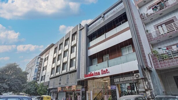 Een meerhoog gebouw met een etalage waarop 'Kashima Int. LUV FASHIONS' staat.
