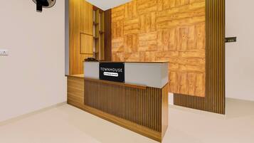 Una recepción con un cartel que indica servicio de la empresa, una pared con diseño geométrico de madera y el número '103' en la pared.