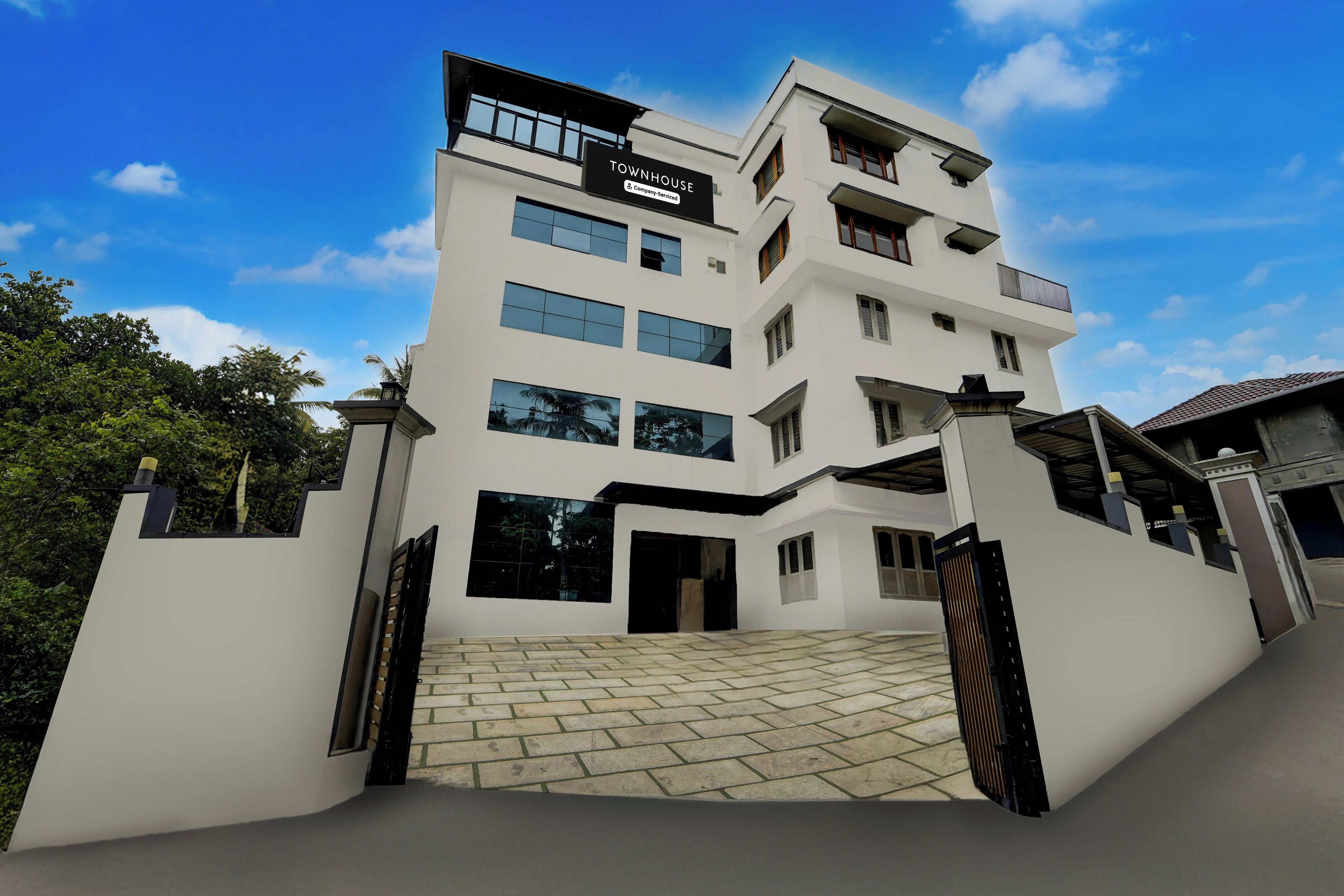 Un edificio de varios pisos con un letrero que dice 'TOWNHOUSE Company Service'.