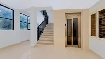 Un interior amplio con escalera, ascensor y ventanas grandes.