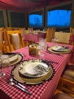 Comedor con mesas dispuestas para dos, con manteles estampados y platos decorativos.