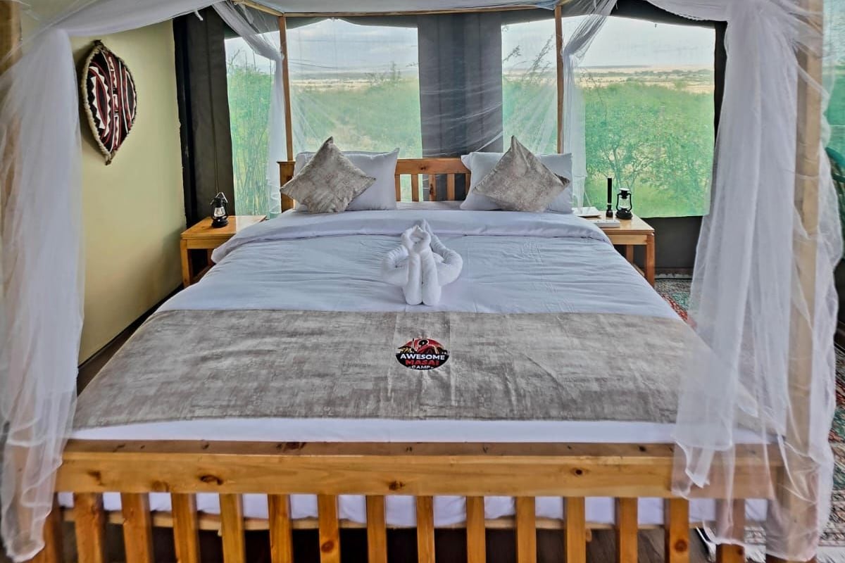 Una habitación con tienda de campaña, una cama, un adorno colgante y vistas al exterior.