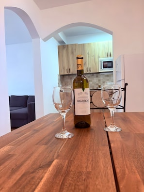 Eine Flasche ValViejo Wein auf einem Holztisch mit zwei leeren Weingläsern.