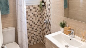 Un baño con ducha, inodoro y lavamanos.