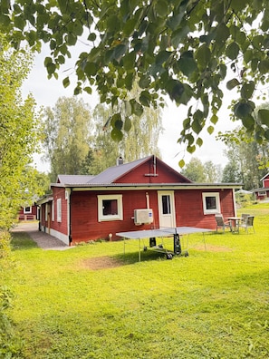 A red house with a covered outdoor area, a table, and chairs. - Vrbo Property (Tärnsjö)