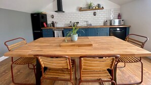 A modern kitchen with a wooden dining table, metal chairs, and pendant lighting. - Secluded converted stables in the heart of the Mourne Mountains. Pet friendly! (Bryansford)