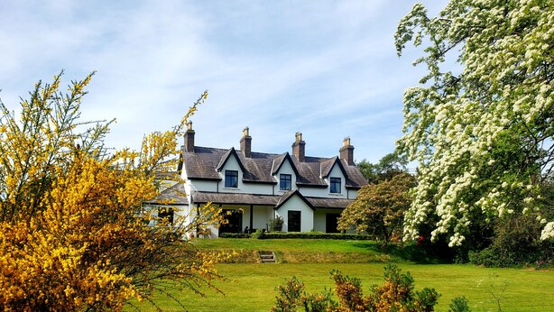 A large, two-story house with a well-maintained lawn and mature trees. - Secluded converted stables in the heart of the Mourne Mountains. Pet friendly! (Bryansford)