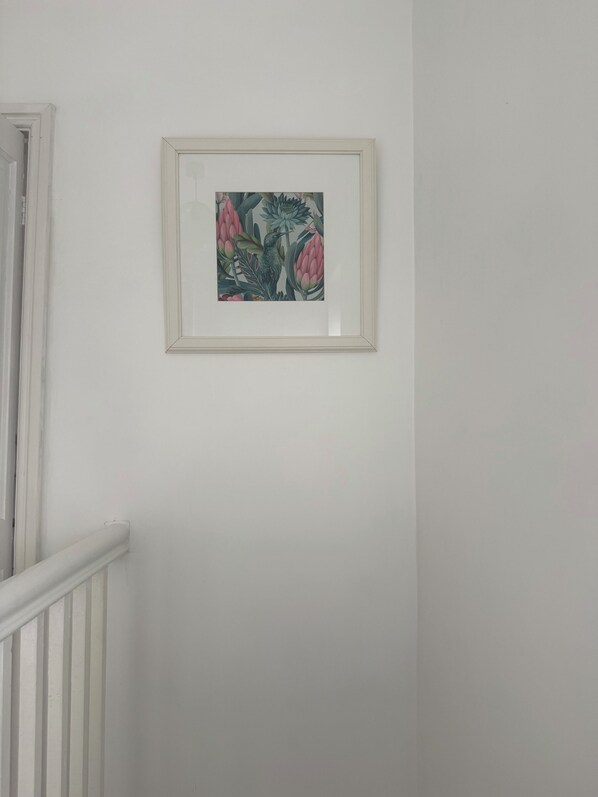 A framed artwork on a plain wall.