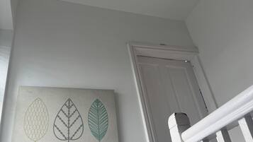 A white wall with a door and a staircase.