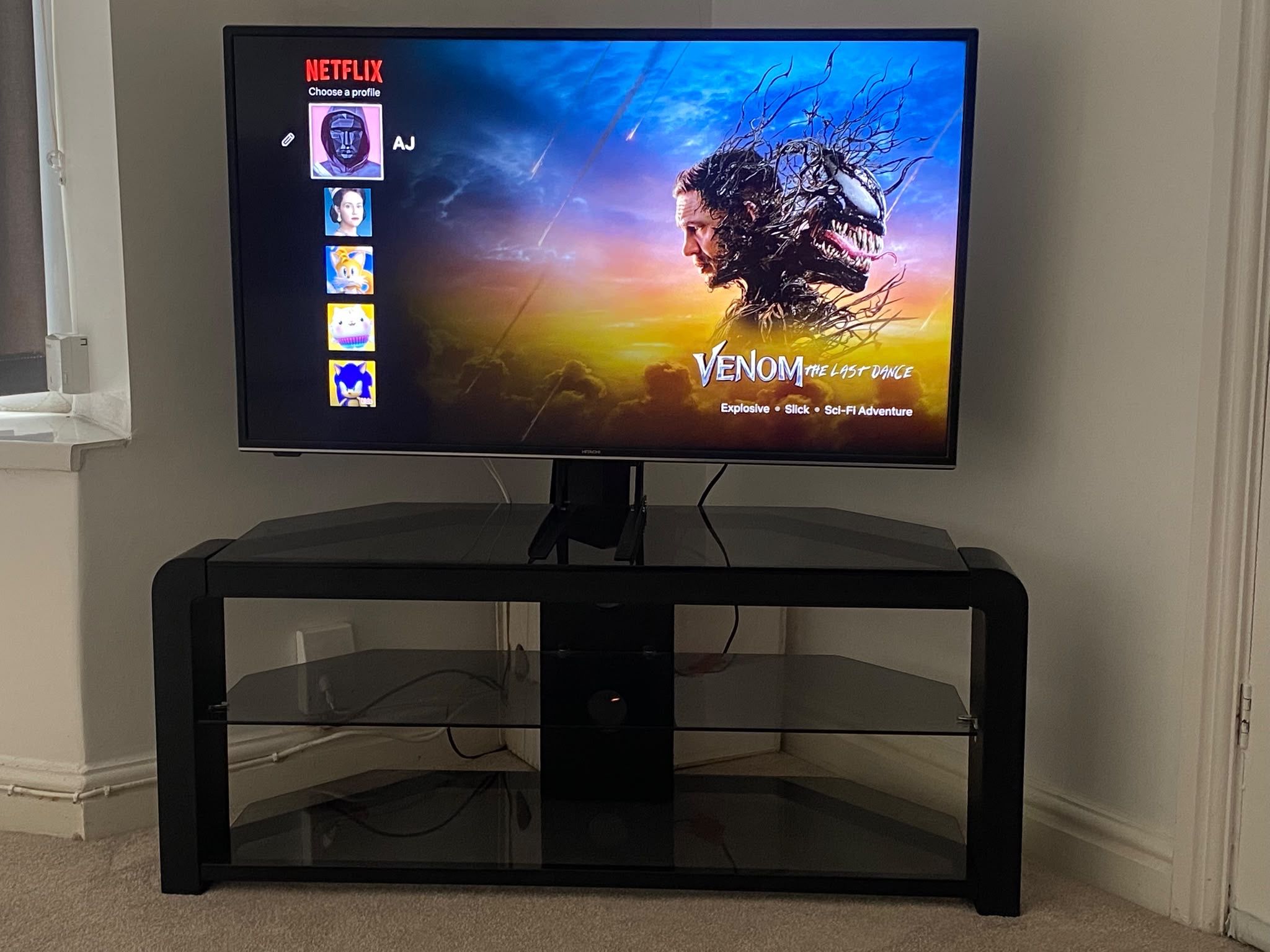 Un televisor sobre un pedestal negro con la interfaz de Netflix mostrando la película 'Venom: The Last Dance'.